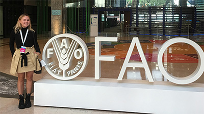 Lindsay Eberhart standing next to F A O sign