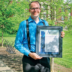 Dr. Chris Whipps with his award for Exemplary Researcher 2021-2022