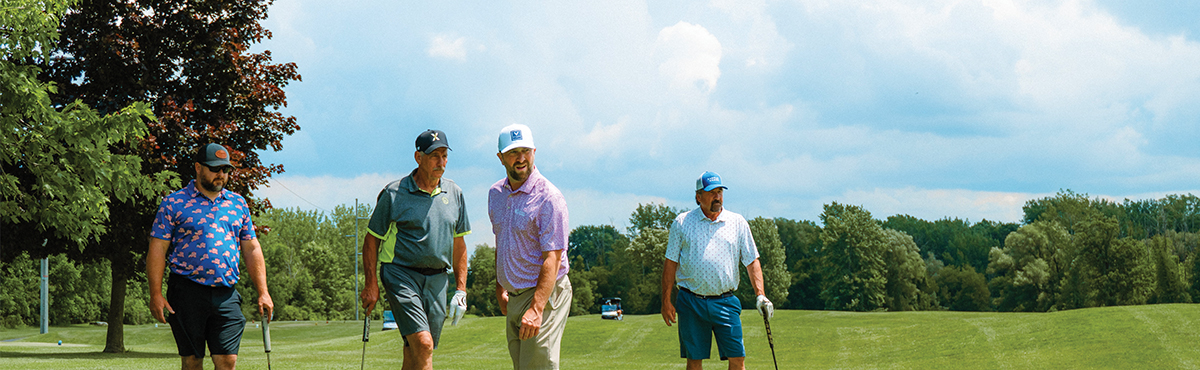 four men on a golf hole with clubs