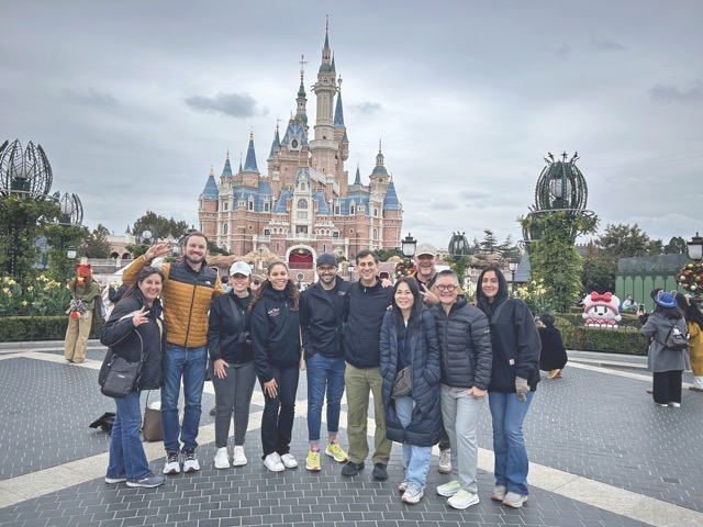group of people standing in front of disney's magic kingdom