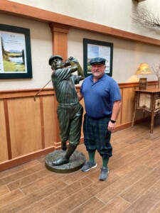 Terrence Croad standing next to a figure swinging a golf club