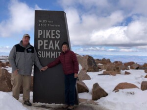 Scott Tait at Pikes Peak Summit with a woman in red jacket