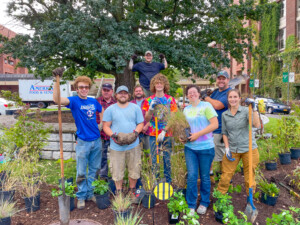 E S F students and staff at pollinator garden planting event with various tools