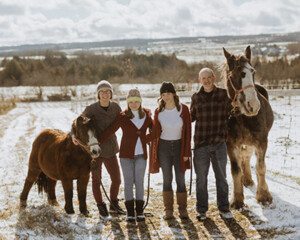 Mickey Dietric, his wife, Adrienne, and their two daughters, Denali and Aurora in Alaska with a horse and a pony.