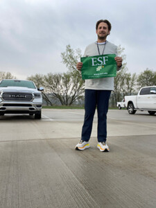 Parrinello holding ESF flag in a parking lot