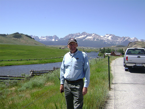 John Snyder standing outdoors. There are mountains in the background